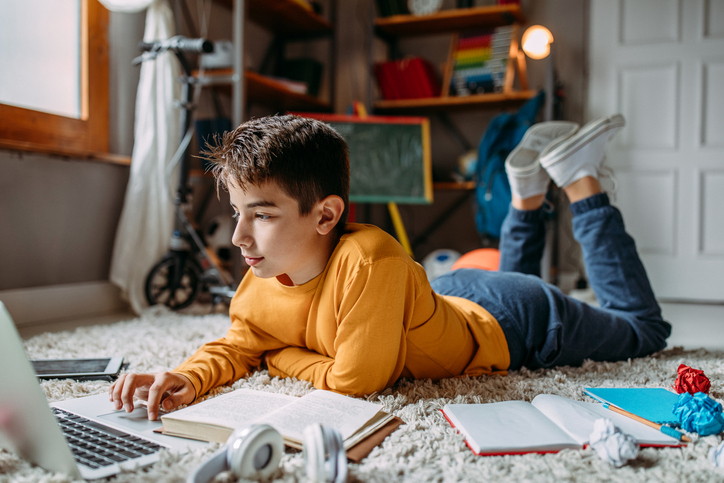 Boy lying on the floor using computer